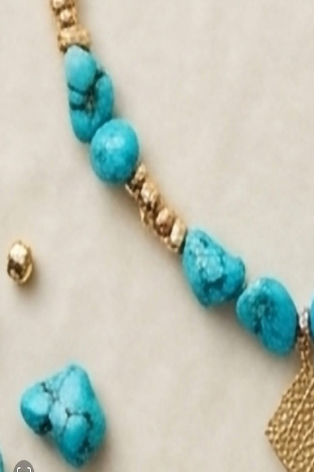 Détail des pierres brutes turquoise et séparateurs dorés