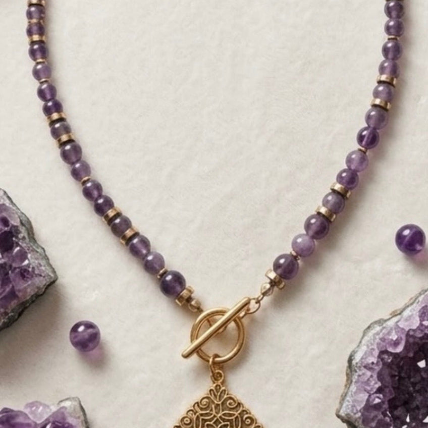 Collier améthyste et pendentif filigrane doré sur fond blanc avec cristaux