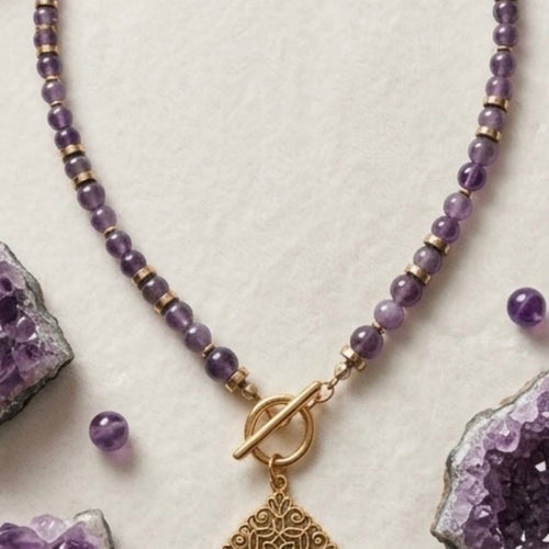 Collier améthyste et pendentif filigrane doré sur fond blanc avec cristaux